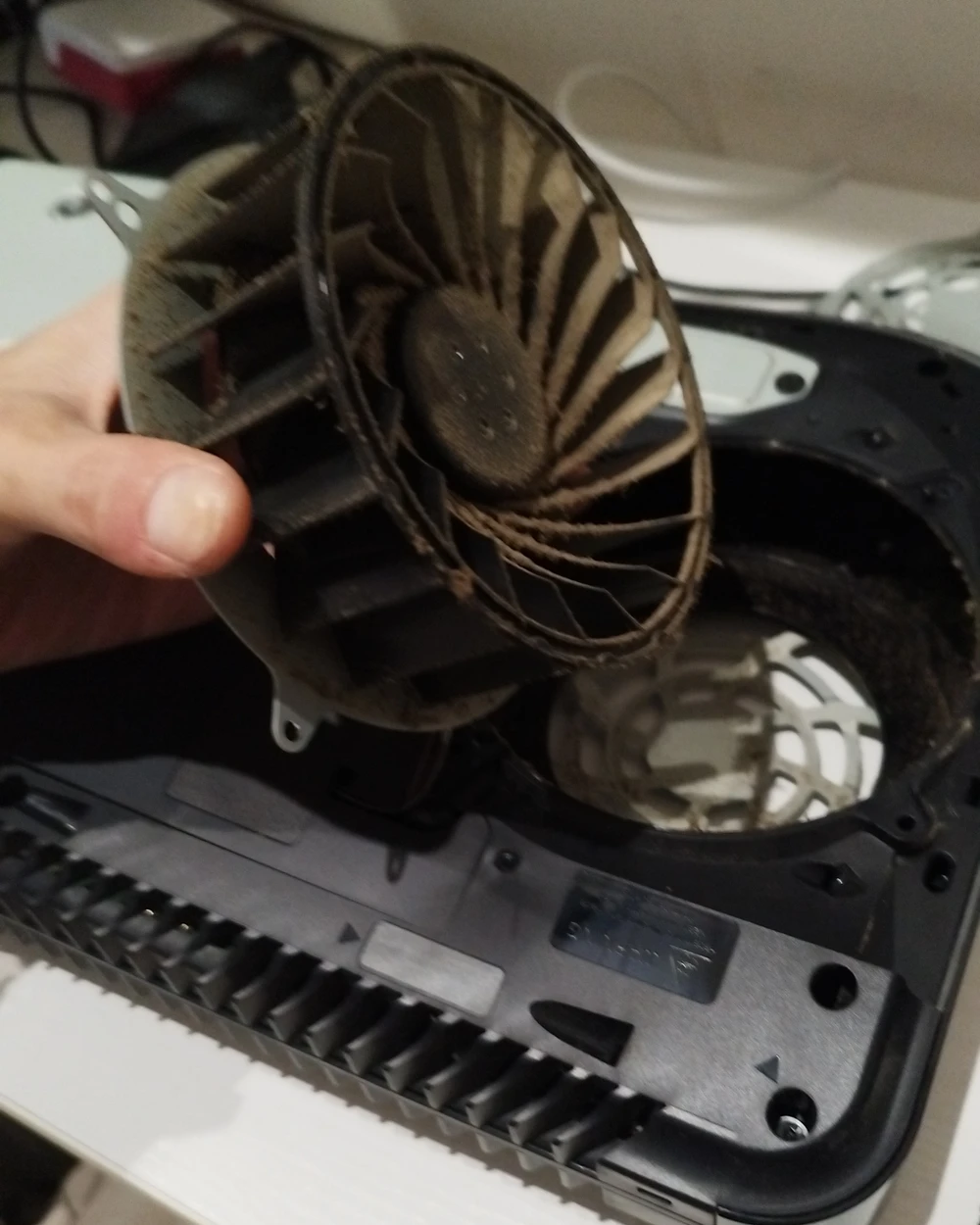 A PS5 fan, removed and covered in dust